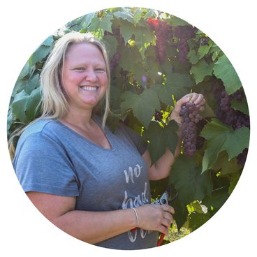 Erin Treiber holding grapes in the vineyard. 